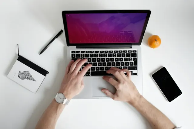 A laptop and notebook in a working space